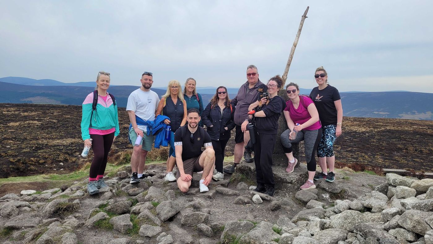 Elan Darcy with Coach Elan clients at the summit on a community day hike in the Irish mountains